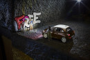 Graffiti-Sprayer beim Besprühen der Treppen-Wand - Modellauto Opel Adam