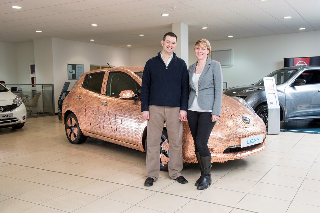 Brett Garner und seine Frau vor dem mit 100 000 Münzen verzierten Nissan Leaf.