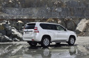 weißer Toyota Land Cruiser Facelift 2014 in der Seiten- Heckansicht