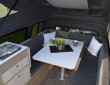 Tisch, Küche und Sitzgelegenheit im Volkswagen Amarok Traveler